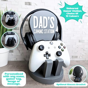 May include: A grey gaming station with a personalised sign that says "DAD'S GAMING STATION". The station includes a headset stand, a controller holder, and an optional glasses bracket. The station is available in 13 colours.
