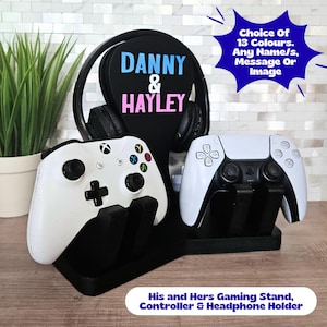 May include: Black gaming stand with white controllers and a headphone holder. The stand features the names "Danny & Hayley" in blue and pink. Text on the stand says "Choice Of 13 Colours. Any Name/s, Message Or Image."
