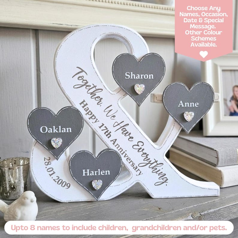 May include: A white wooden ampersand sign featuring three grey heart-shaped plaques with the names Sharon, Anne, and Harlen. The sign includes the text Together, We Have Everything, Happy 17th Anniversary, and the date 28.01.2009, with small crystal accents.