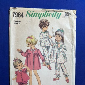 May include: A vintage Simplicity sewing pattern for toddler pajamas. The pattern is for sizes 3 and includes three different styles of pajamas. The pattern is from 1968 and costs 65 cents.