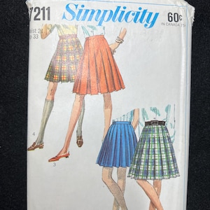 May include: Vintage Simplicity sewing pattern envelope featuring illustrations of pleated skirts in various colors and patterns. The envelope includes the text "Simplicity" and the number "7211". The price is listed as 60¢.