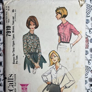 May include: Vintage McCall's sewing pattern for blouses, featuring three different styles. The pattern is for sizes 8-10 and has a bust measurement of 28-29 inches. The pattern is titled "Blouses for Three Figure Types: Misses, Teen and Pre-Teen." and is numbered 7919.
