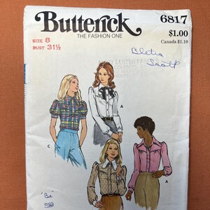 May include: Vintage Butterick sewing pattern, size 8, featuring illustrations of blouses. The pattern includes various blouse styles with details like puff sleeves, collars, and button-down fronts. The text "Butterick" and "THE FASHION ONE" are at the top.