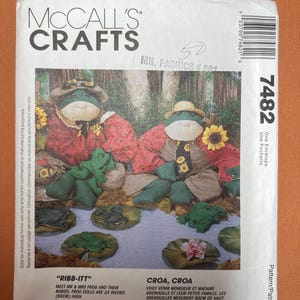 May include: McCall's Crafts pattern envelope featuring frog dolls. The pattern includes instructions to create frog dolls that are 24 inches (60cm) high. The envelope has a colorful illustration of the finished dolls in a pond setting.