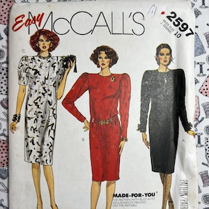 May include: A sewing pattern for a dress with three different styles. The pattern is for size 10 and is called McCall's Easy 2597. The pattern features built-in fit adjustments and bust size adjustment darts for C and D cup sizes.