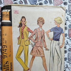 May include: Vintage sewing pattern for a junior petite outfit. The pattern includes a jacket or vest, pants, skirt, and blouse. The pattern is from McCall's and the number is 9749.