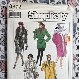 May include: Simplicity sewing pattern number 8872 for coats. The pattern includes four different styles: a white coat with a belt, a green coat with a belt, a pink coat, and a yellow coat. The pattern is labeled "Family Pathways" and includes instructions for sizes 8-18.