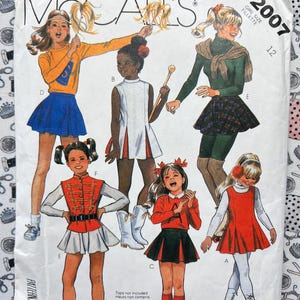 May include: McCall's sewing pattern envelope featuring illustrations of girls in various outfits. The cover includes the text "McCall's" and "2007". The outfits include skirts, tops, and a marching band style uniform.