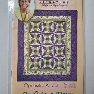 May include: A quilt pattern titled "Opposites Attract" by Teresa Varnes. The pattern features a central design of purple and green geometric shapes, surrounded by a floral border. The package includes a photo of Eleanor Burns and the text "Quilt in a Day".