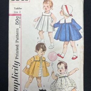 May include: Vintage Simplicity printed pattern for a toddler size 2. The cover features illustrations of four different dresses and coats. The price is listed as 50¢ in Canada 60¢. The pattern number is 3843.