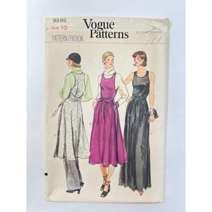 May include: Vogue Patterns 9595 sewing pattern envelope, size 10. The illustration shows three variations of a sleeveless dress with a tie waist, worn over long-sleeved tops. The designs include a patterned midi length, a solid magenta midi, and a solid black floor-length dress.