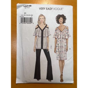 May include: A Very Easy Vogue sewing pattern, V9238, featuring two off-the-shoulder designs. One is a striped top with flared pants, and the other is a floral print dress. The pattern includes sizes 14-16-18-20-22.