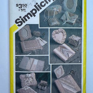 May include: Simplicity sewing pattern featuring various fabric-covered boxes and decorative items. The pattern includes a heart-shaped box, a rectangular box with lace trim, and other embellished designs. The cover has the text "Simplicity" and "marjorie puckett".