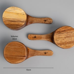 May include: Three wooden scoops of varying sizes, with handles. The largest scoop is labelled "Volume: 30ml". The scoops are 5cm tall and 10cm wide.