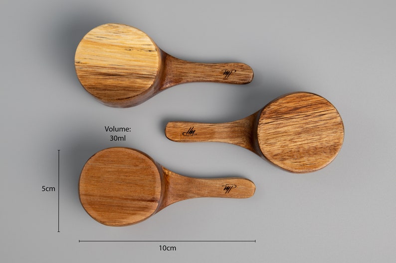 May include: Three wooden scoops of varying sizes, with handles. The largest scoop is labelled "Volume: 30ml". The scoops are 5cm tall and 10cm wide.