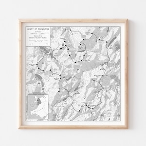 May include: A black and white map of the Heart of Snowdonia, a mountain range in Wales. The map shows the location of 25 peaks, including the highest peak, Snowdon. The map also shows the location of several towns and villages, including Llanberis, Beddgelert, and Blaenau Ffestiniog.