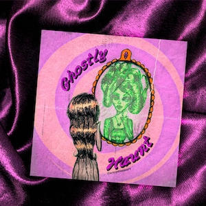 Puede incluir: Una ilustración rosa y naranja de una mujer mirando en un espejo. La mujer en el espejo tiene el pelo verde y lleva un vestido verde. El texto "Ghostly Haunt" está escrito en letras moradas y rosas. El texto "@anpravaaart" está escrito en letras negras en la parte inferior de la imagen.
