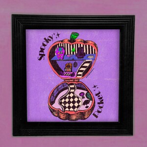 May include: A purple and pink illustration of a spooky compact mirror with a black and white checkered interior. The compact is shaped like an apple and has the words "Spooky Pocket" written on it.