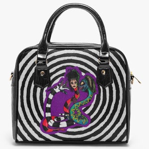 Puede incluir: Bolso de mano de patrón de remolino blanco y negro con un gráfico morado, verde y negro de una mujer y dos serpientes.