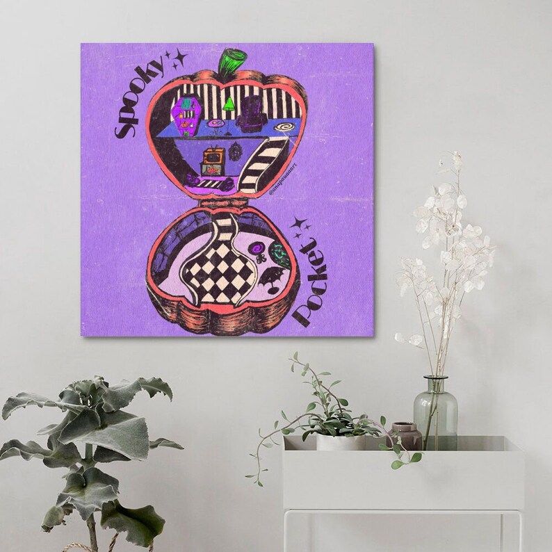 May include: A purple background with a cartoon illustration of a pumpkin-shaped compact mirror. The mirror is open and reveals a miniature room with a checkered floor, a fireplace, a television, and a bed. The text "Spooky Pocket" is written on the mirror.