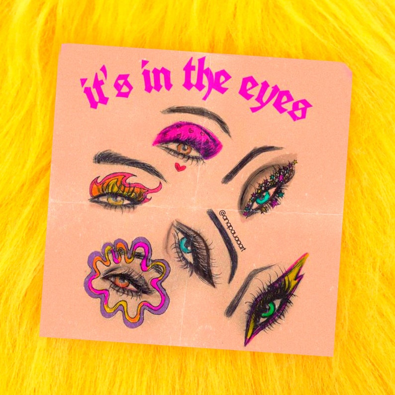May include: A pink and peach background with the text "it's in the eyes" in pink. There are five different eye illustrations with colorful makeup and details. The eyes are drawn in a cartoon style.