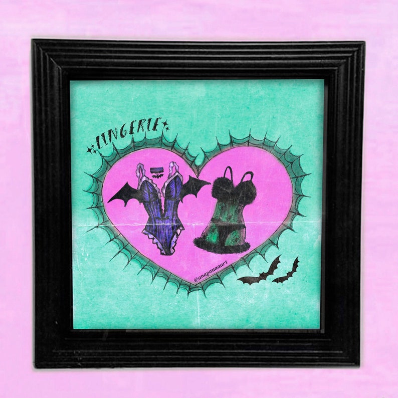 May include: A framed illustration of a heart with a spiderweb design. Inside the heart are two pieces of lingerie, one black and one purple, with bat wings. The text "Lingerie" is written above the heart.