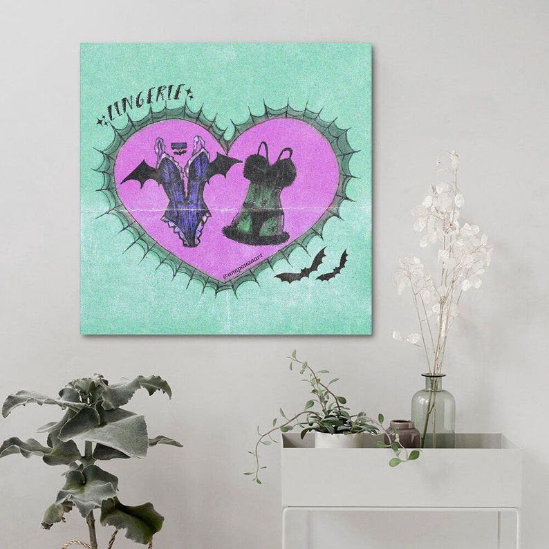May include: A green and pink heart with a black and purple lingerie set and a black and green lingerie set inside. The heart is surrounded by a black thorny border and there are two black bats on the green background. The text "LINGERIE" is written in black at the top of the image.