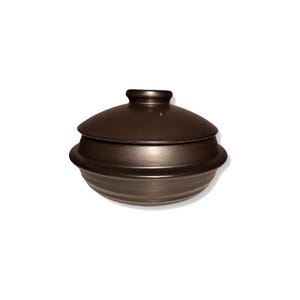 May include: A brown ceramic pot with a lid. The pot has a rounded shape and a slightly flared rim. The lid fits snugly on top of the pot.