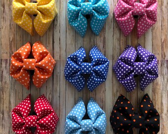 May include: Nine polka dot bow ties in various colors, including yellow, blue, pink, orange, red, purple, light blue, black, and orange. The bow ties are all made of fabric and have white polka dots.