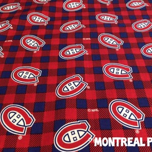 May include: Red and blue plaid fabric with the Montreal Canadiens logo repeated across the surface. The logo is a white "H" inside a red circle with a blue outline. The text "MONTREAL PLAID" is visible.