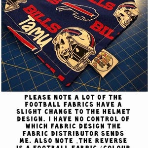 May include: Blue and red dog bandana with a Buffalo Bills football helmet pattern. The bandana has the word "Tami" written on it. The text "PLEASE NOTE A LOT OF THE FOOTBALL FABRICS HAVE A SLIGHT CHANGE TO THE HELMET DESIGN. I HAVE NO CONTROL OF WHICH FABRIC DESIGN THE FABRIC DISTRIBUTOR SENDS ME. ALSO NOTE, THE REVERSE IS A FOOTBALL FABRIC (COLOUR COULD CHANGE) THAT I HAVE AND COULD BE DIFFERENT AS STATED IN MY LISTING DESCRIPTION! THANKYOU FOR UNDERSTANDING :)" is also visible in the image.