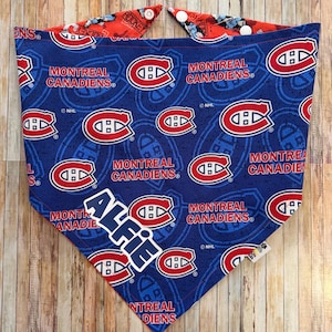 May include: A blue dog bandana featuring the Montreal Canadiens logo and team name. The bandana has a red and white design on the reverse side and includes the name "Alfie". The NHL logo is also visible.