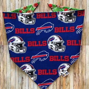 May include: Blue bandana with a white and red Buffalo Bills logo pattern. The bandana has a green and brown football field pattern on the reverse side.