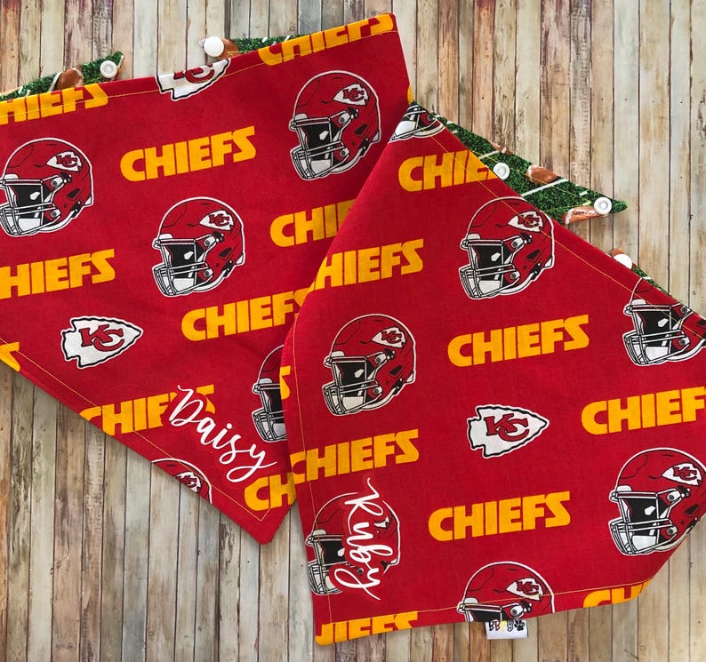 May include: Two red and yellow fabric dog bandanas with a Kansas City Chiefs pattern. One bandana says "Daisy" and the other says "Riley".