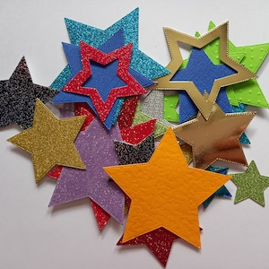 Troqueles de estrellas, globos y corazones en varios tonos, diseños, tamaños y texturas de cartulina. Hay 30 en cada paquete.