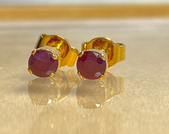 Puede incluir: Un par de pendientes de botón de oro con piedras redondas de rubí rojo oscuro.