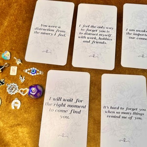 May include: Five white cards with black text on a gold background. The cards have quotes about love, loss, and connection.  The text on the cards reads: "You were a distraction from the misery I feel." "I feel the only way to forget you is to distract myself with work, hobbies and friends." "I am awakening to the importance of our connection." "I will wait for the right moment to come find you." "It's hard to forget you when so many things remind me of you."