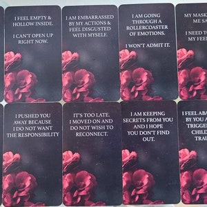 K&ouml;nnte beinhalten: Ein Satz Tarotkarten mit dunklem Hintergrund und floralen Akzenten. Jede Karte zeigt einen anderen Satz in wei&szlig;em Text, wie z. B. "Ich f&uuml;hle mich leer und hohl". Die Karten sind in Reihen angeordnet.