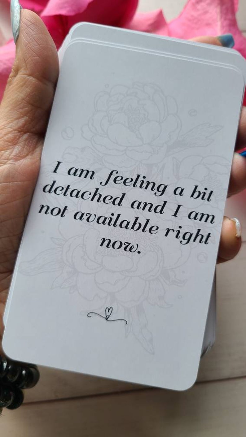 May include: A white card with a floral design and the text "I am feeling a bit detached and I am not available right now."