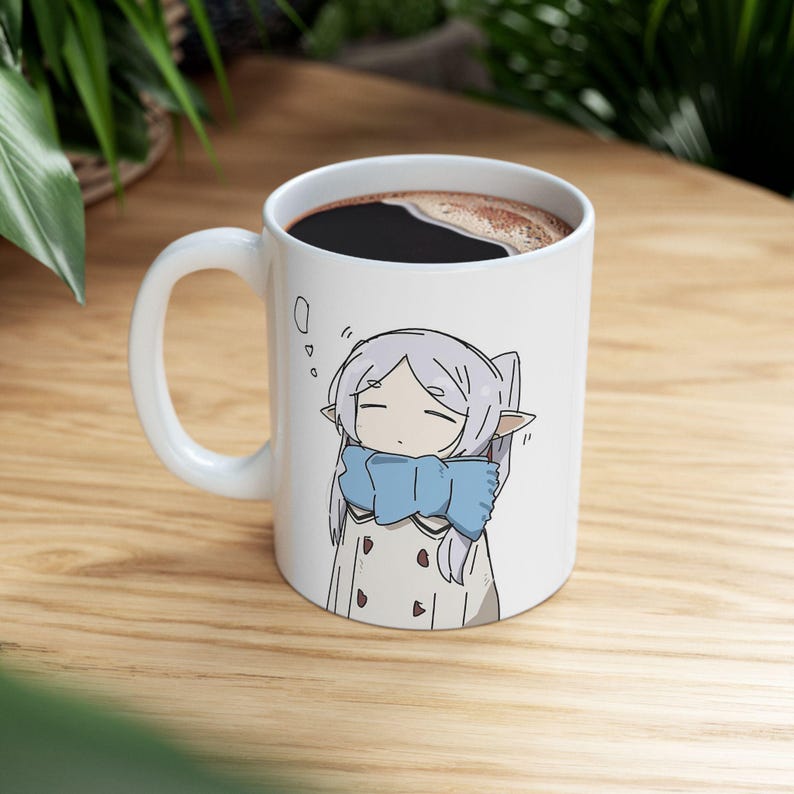 May include: White ceramic mug with a cartoon illustration of a girl with purple hair wearing a blue scarf. The mug is filled with coffee.
