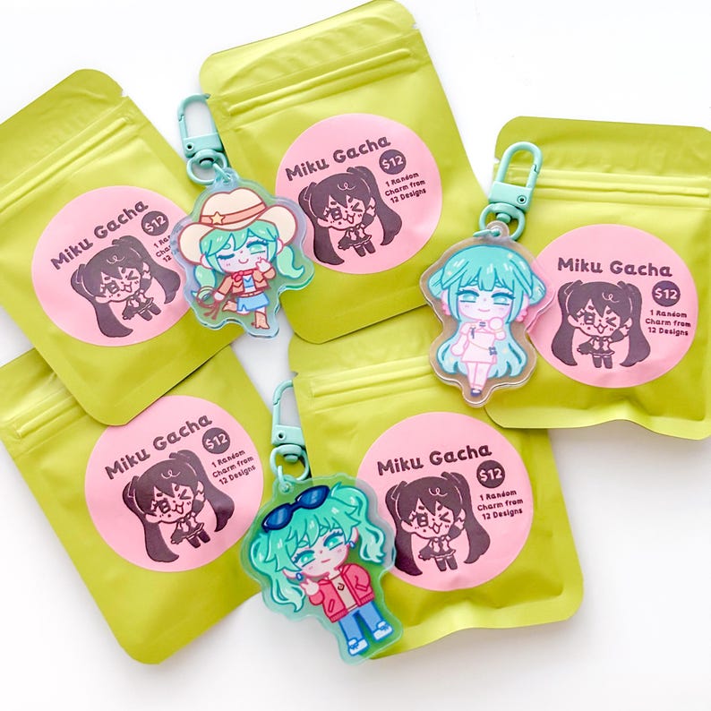 May include: Several green pouches with pink circular stickers that read "Miku Gacha" and "$12".  Attached are clear acrylic charms of a cartoon character with teal hair. One charm has a cowboy hat, another has sunglasses.