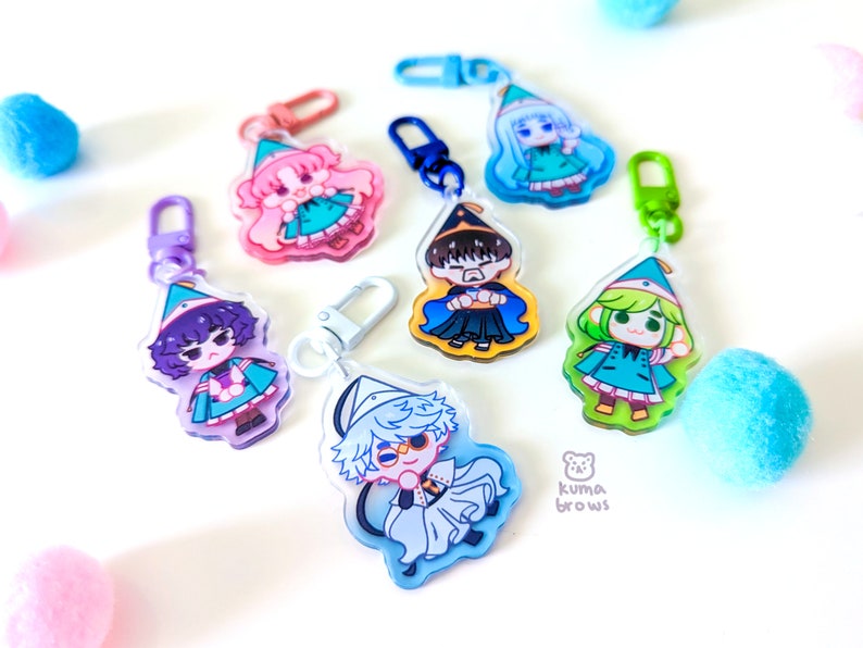 May include: Set of six colorful cartoon character keychains with a whimsical design. Each keychain features a different character wearing a pointed hat and a colorful outfit. The keychains are made of clear acrylic and have a metal ring for attaching to keys or bags.