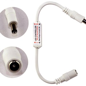 May include: White LED controller with a red label that says "LED CONTROLLER with RF Remote Control Peak Output Current: 6A 5-24". The controller has two white connectors with a black center.