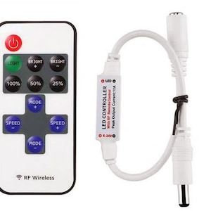 May include: White LED controller with a remote control. The controller has a white wire with a plug on the end. The remote control has buttons for light, brightness, speed, and mode. The text on the controller reads "LED Controller with RF Remote Control Peak Output Current: 12A 5-24V".