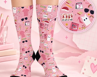 May include: A pair of pink crew socks featuring a repeating pattern of various icons including a calendar marked October 3rd, a pink shirt, black sunglasses, a red Santa hat, a pink high heel, and a book labeled Burn Book with black heels.