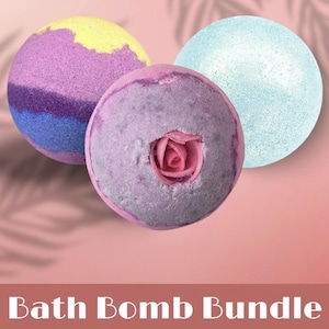 May include: Three colorful bath bombs. One is purple with yellow, blue, and purple layers. Another is light purple with a pink rose in the center. The third is light blue. The text "Bath Bomb Bundle" is at the bottom.