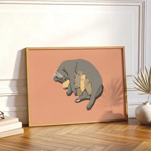 Könnte beinhalten: Ein gerahmter Kunstdruck mit einer grauen Katze, die Kätzchen säugt. Das Kunstwerk hat einen minimalistischen Stil mit einem pfirsichfarbenen Hintergrund. Die Katze und die Kätzchen sind in vereinfachter, illustrativer Weise dargestellt, mit einem Holzrahmen.