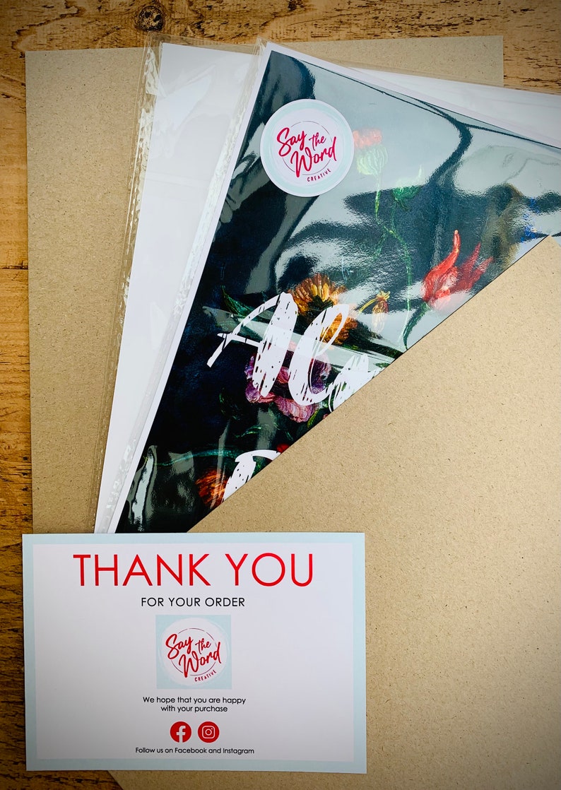 May include: An art print with a floral design is packaged with a thank you card. The print is sealed in a clear plastic sleeve and placed inside a cardboard envelope. The thank you card has the text "THANK YOU FOR YOUR ORDER".