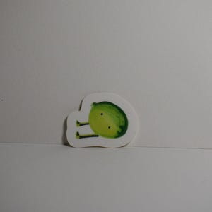 May include: A white sticker featuring a cartoon lime character with a green and yellow body, black legs, and two black dots for eyes. The lime is set against a plain white background.
