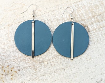 May include: A pair of teal blue circle earrings with a silver bar hanging from each circle.